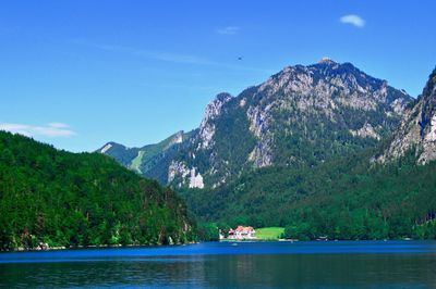 Scenic view of sea and mountains against blue sky