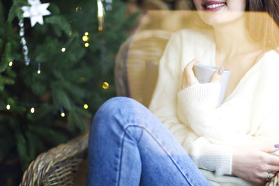 Midsection of woman sitting on tree