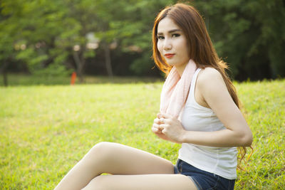 Woman sitting on field at park