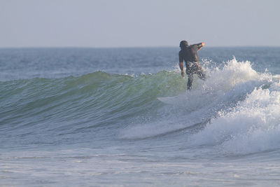 Man surfing on sea against clear sky