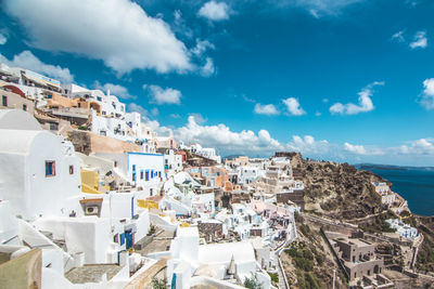 High angle view of townscape by sea against sky in oia, santorini greece