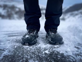 Low section of person standing on snow