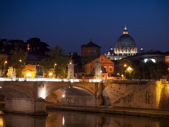 Illuminated buildings against sky at night in city