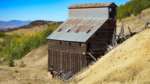 House by mountain against clear sky