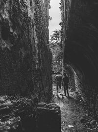 People walking on footpath against wall