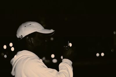 Side view of man holding equipment at night