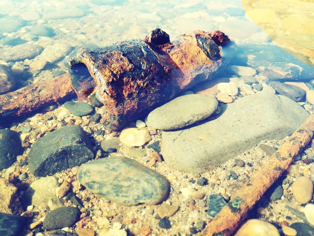 water, high angle view, beach, rock - object, sea, shore, stone - object, nature, sand, outdoors, sunlight, day, tranquility, rock, cloud - sky, sky, stone, puddle, abandoned, beauty in nature