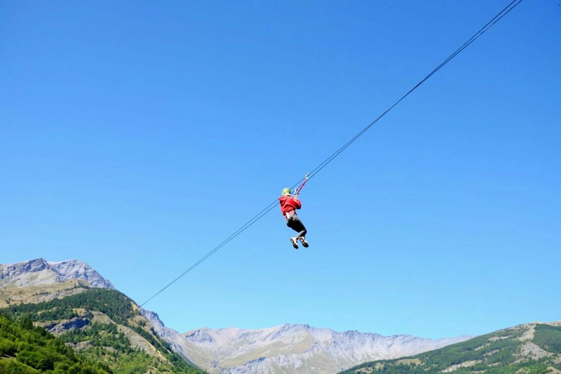 extreme sports, adventure, leisure activity, mountain, lifestyles, clear sky, mid-air, men, sport, transportation, paragliding, parachute, unrecognizable person, blue, low angle view, mountain range, copy space, vacations