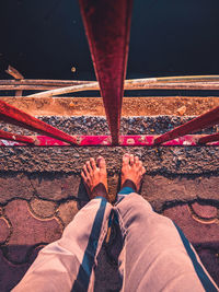 Low section of man standing on bridge over river