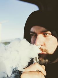 Portrait of young man smoking cigarette