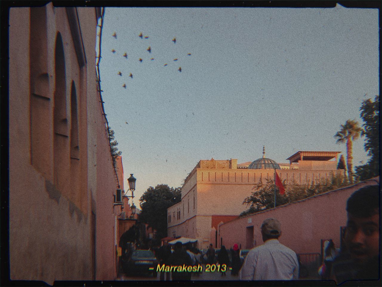 PEOPLE ON STREET AMIDST BUILDINGS AGAINST SKY