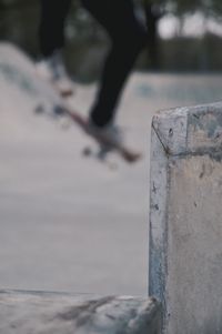 Low section of person jumping on concrete wall