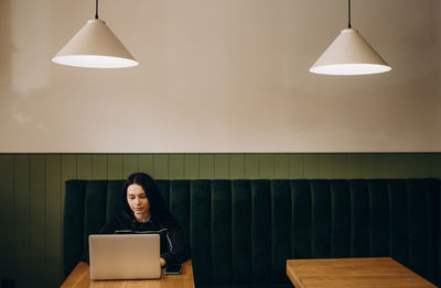 Portrait of young woman using laptop at home