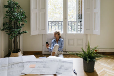 Full length of woman sitting on table