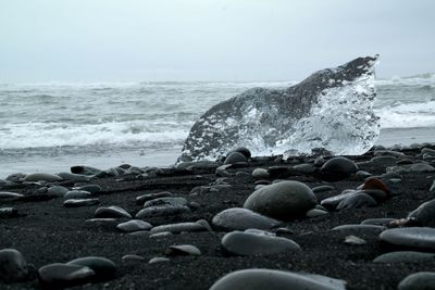 Pebbles on beach against sky