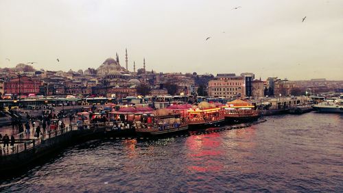 River amidst buildings in city against sky