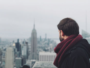 Rear view of man looking at city buildings