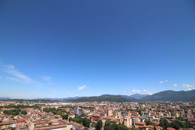 Aerial view of townscape against blue sky