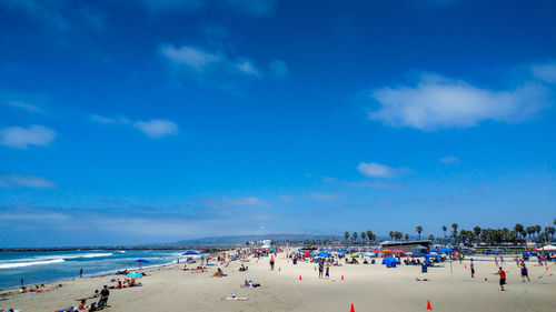 Group of people on beach against sky