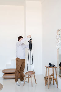 Man photographing against wall