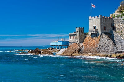 Buildings at waterfront against blue sky