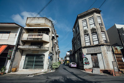 Road amidst buildings in city against sky