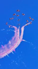 Low angle view of airshow against blue sky