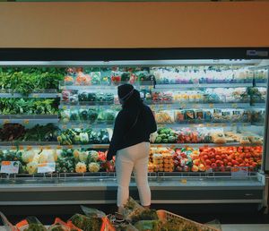 Rear view of man standing at market stall