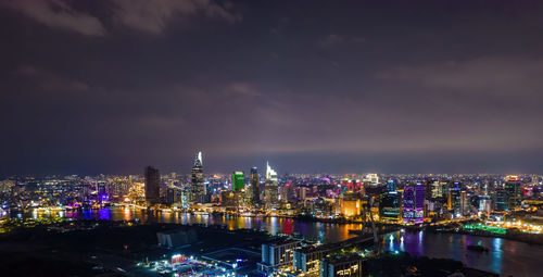 Illuminated buildings in city against sky at night