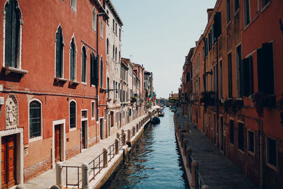 Canal amidst buildings against sky in city