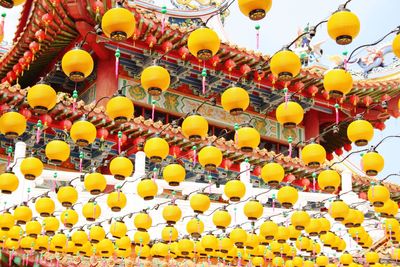 Low angle view of lanterns hanging against sky