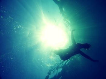 Low angle view of silhouette person swimming in sea