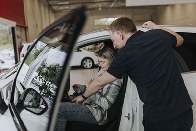 Salesman and female customer in car dealership