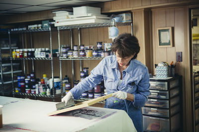 Craftswoman examining ink prints on fabric at workshop