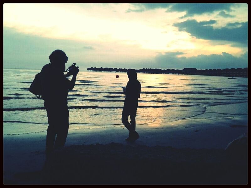 transfer print, silhouette, water, sea, sky, lifestyles, standing, leisure activity, sunset, auto post production filter, beach, men, full length, cloud - sky, tranquility, tranquil scene, scenics, shore