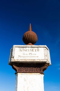 Low angle view of information sign against clear blue sky