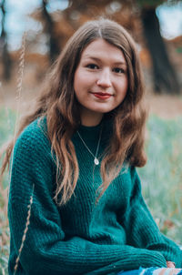 Portrait of smiling girl sitting on field