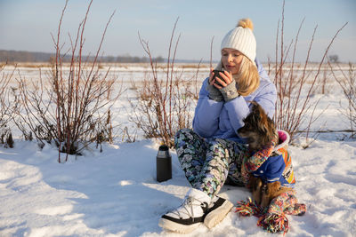 Rear view of woman standing on snow covered field