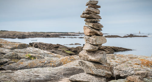 Stack of rocks on beach against sky