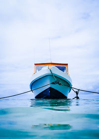 Sailboat moored on sea against sky