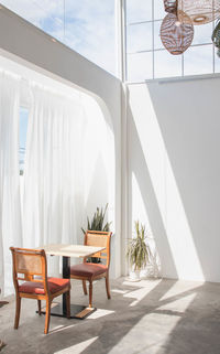 Empty chairs and table against building