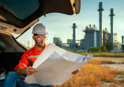 Engineer looking at refinery plans.