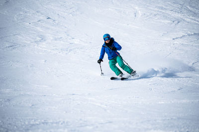 Full length of woman skiing on snow