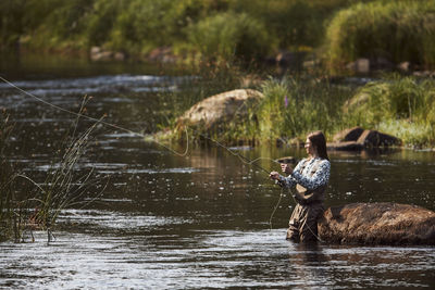 Woman fishing in lake