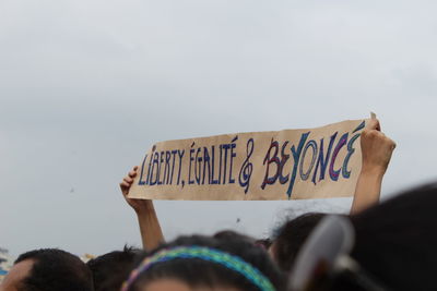 People holding banner against sky