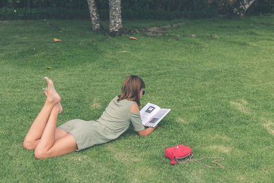 Woman lying on grassy field