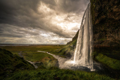 Scenic view of waterfall against sky