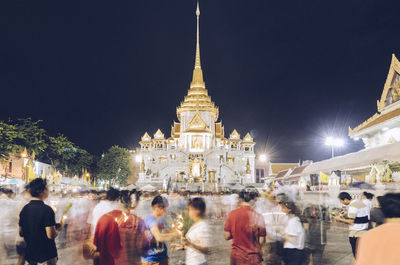 Group of people in front of buildings at night