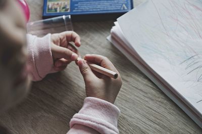 High angle view of woman holding hands on table