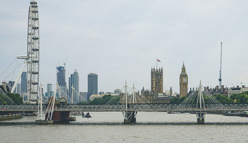 Bridge over river against cloudy sky